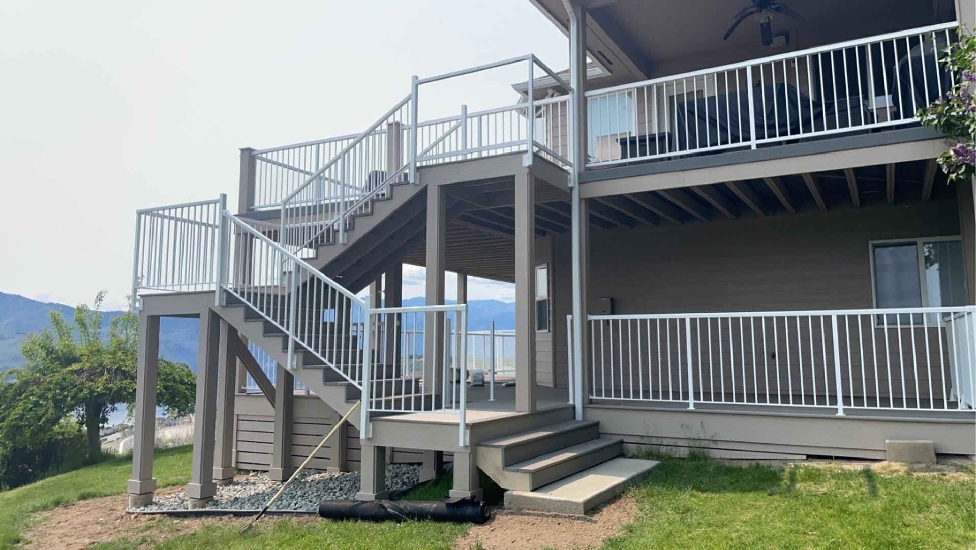 Two story deck with stairs and white railing on a home