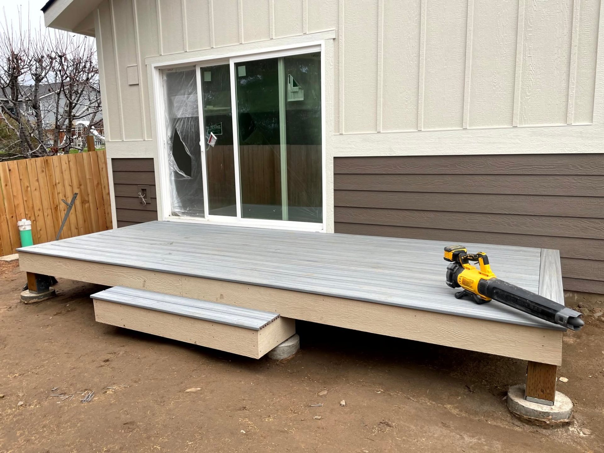 Low-profile gray composite platform deck at a sliding glass door